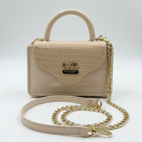 Beige handbag with a gold chain on a light gray background